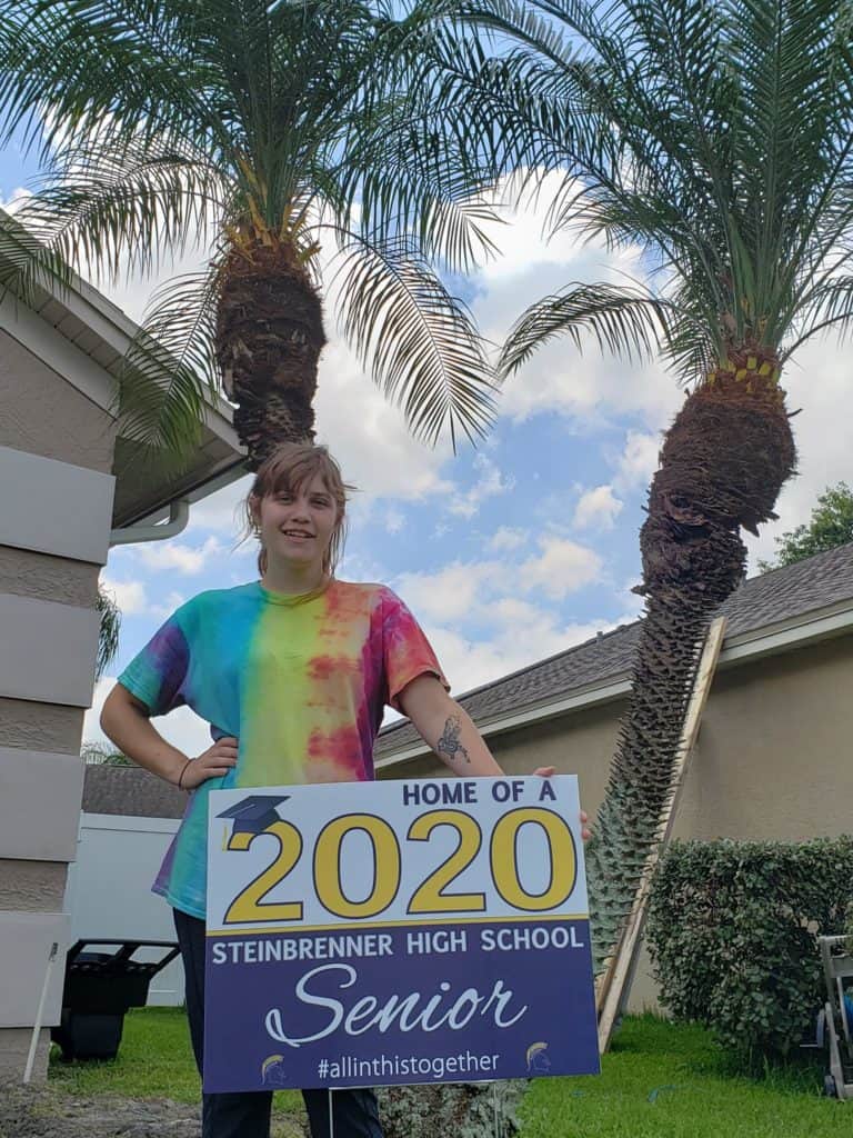 Ashlee with graduation sign