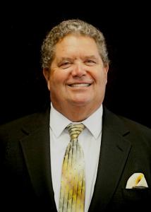 Photo of Patrick Wilkins in suit and tie against black background used as professional image