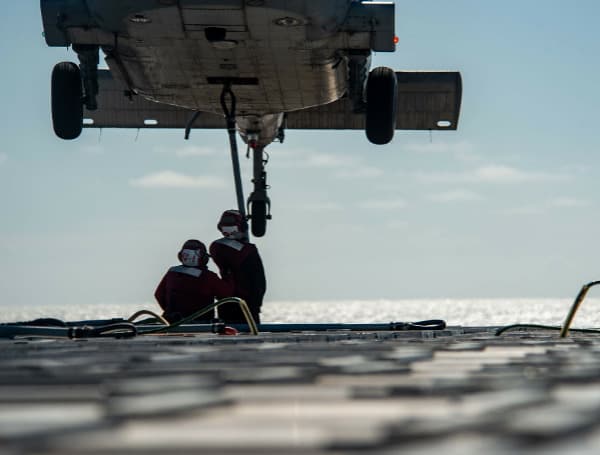 Aviation Ordnanceman 3rd Class Destiny Deleon, left, from San Antonio, and Aviation Ordnanceman Airman Angel Banak, from Tampa, Florida, attach cargo to an MH-60S Sea Hawk