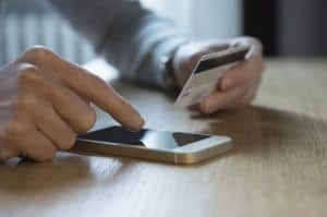 Person securely typing their credit card number on phone with 1800 Notify Payment IVR
