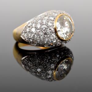 A gold dome-shaped ring with a large diamond surrounded by smaller diamonds.