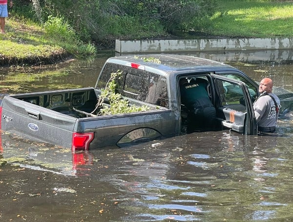 A Ford F-150 has become submerged in a pond within the Land O' Lakes subdivision Wilderness Lake Preserve.