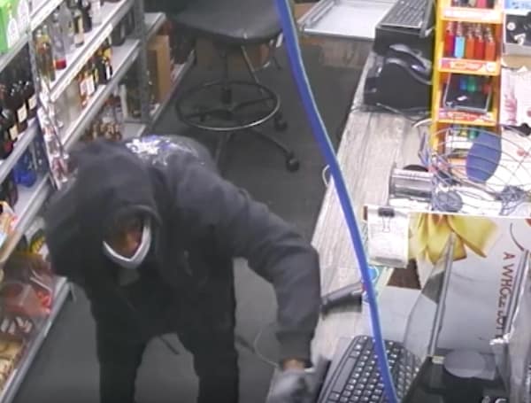 Tampa Police are investigating an early morning commercial burglary that occurred on Armenia Avenue at Quick Pick Liquors. Video surveillance shows the suspect wearing a black hoodie with a large blue and white graphic on the back, and a white facemask during the burglary.