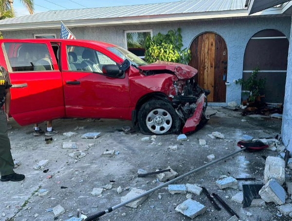 A woman and her dog escaped injury this morning after the driver of a pickup truck lost control of his vehicle and crashed into the home.
