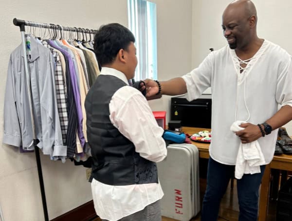 Joseph Streets, an alumni of Hillsborough High School, helps a student pick out clothes for the prom as part of the Prom Project. Photo supplied by Terrier National Volunteers